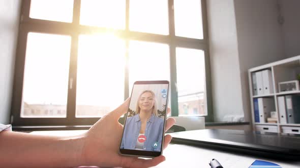 Hand Holding Smartphone with Video Call at Office