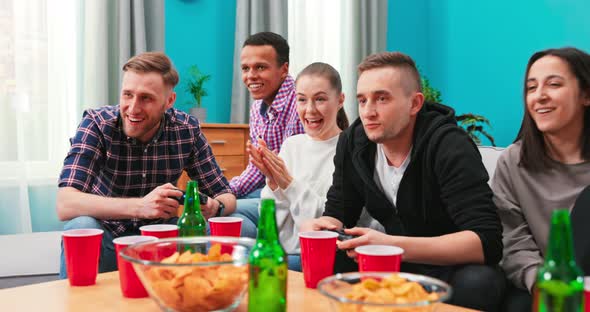 Group of Friends Play Video Games Together at Home Having Fun