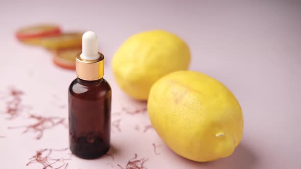 Essential Oil Bottle and Lemon on Yellow Background