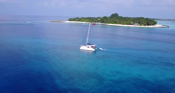 Daytime fly over travel shot of a summer white paradise sand beach and blue ocean background in high