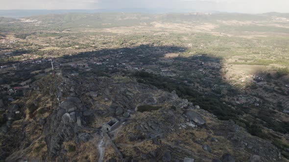 Aerial pullback reveal Stone scenery with Monsanto Medieval Castle on Hilltop