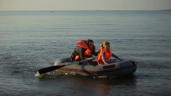 Mother and Child in Life Vests Rowing Boat to Shore, Refugees Survived Shipwreck