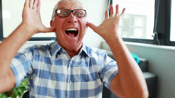 Portrait of senior man making funny faces for camera