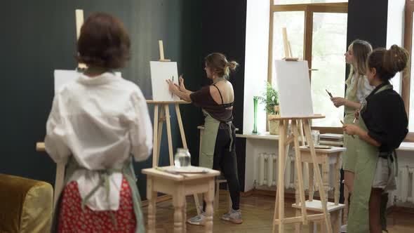 Group of Students Painting at Art Lesson in Studio
