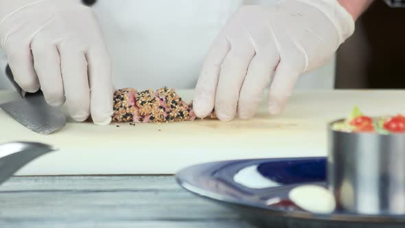 Hands Cutting Roasted Tuna.