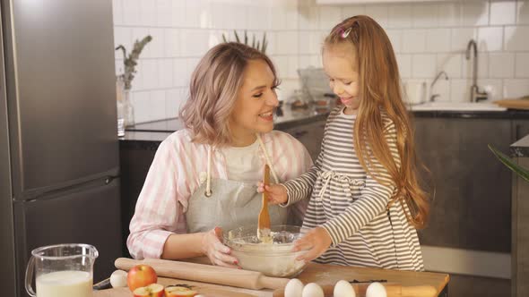 Happy Family Mom and Daughter Prepare Pizza Dough Cake Cookies at Home