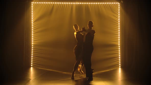 A Couple of Dancers Press Their Bodies Closely Together As They Perform Tango in a Dark Studio