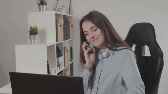 Girl Talking on the Phone with a Laptop