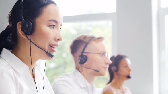 Diverse team of young professionals is working in the phone support office.