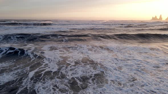 Drone Over Surf On Beach With Reynisdrangar Sea Stacks