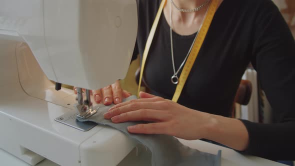 Woman Using Sewing Machine in Dressmaking Studio