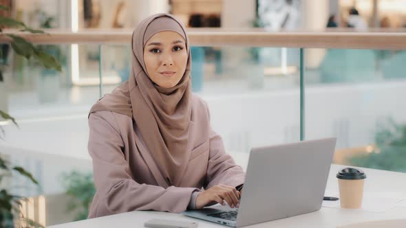 Confident Muslim Businesswoman Freelancer in Hijab Working Typing on Laptop Chatting Makes Purchases