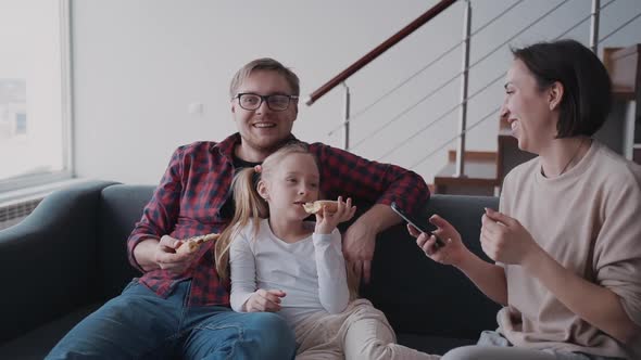 Father Hugging Little Daughter While His Wife Using Cellular