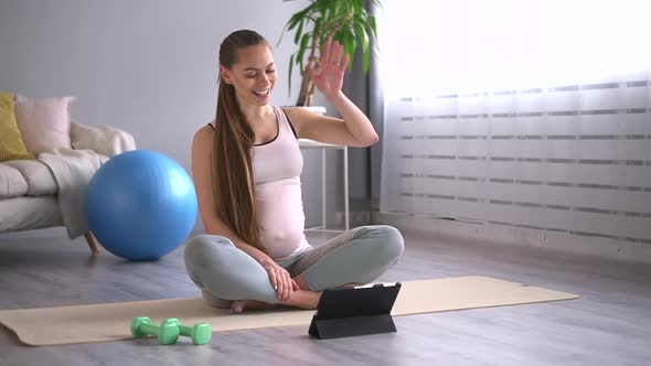 Pregnant Woman Having Online Talk and Sitting on Floor While Practicing Yoga in Apartment Spbd