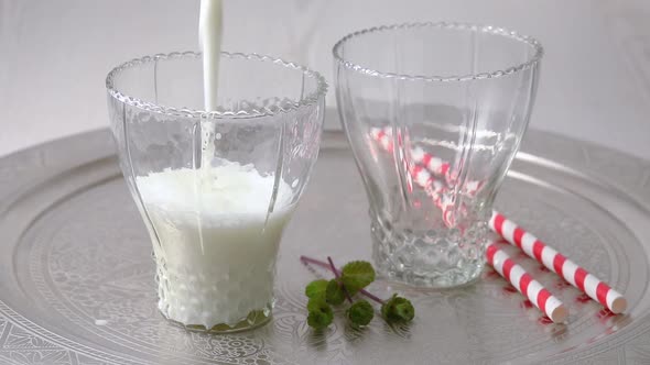 Pouring fresh white creamy traditional Ayran in glasses