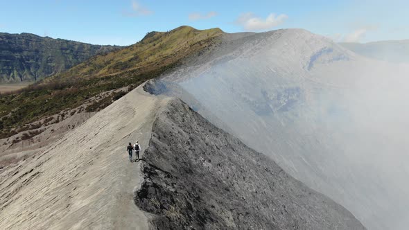 Hikers walking on ridge of Mount Bromo volcano