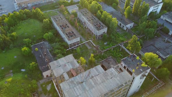 Old White Factory Buildings. Aerial shot of an old abandoned big factoty with a long smoke stack