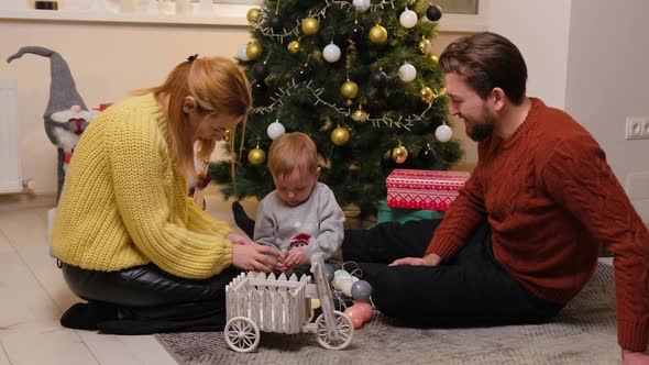 Happy Family Having Fun and Playing Together Near Christmas Tree