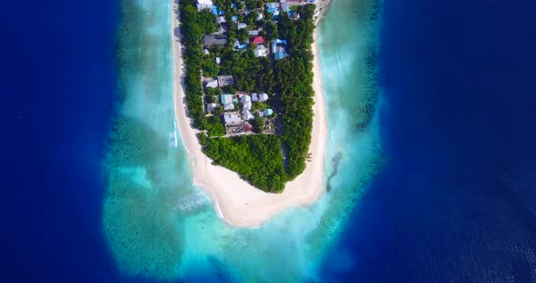 Daytime birds eye travel shot of a sunshine white sandy paradise beach and aqua blue ocean backgroun