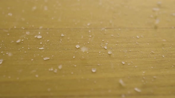 Salt Falls on a Wooden Surface. Macro Shot of Salt Crystals. Slow Motion.