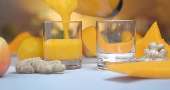 Pumpkin and Ginger Smoothie is Poured Into Glasses Against a Background of Fresh Vegetables and