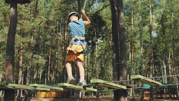 Boy Child Overcomes an Obstacle Course in a Rope Town