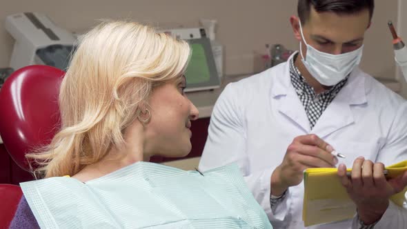 Happy Female Patient Showing Thumbs Up Sitting in Dental Chair at the Dentists