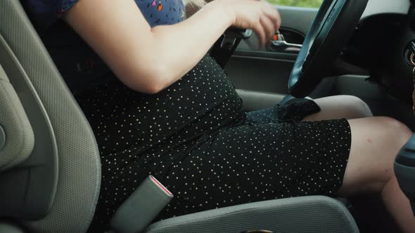Pregnant Woman Car Driver Fastens Seat Belt