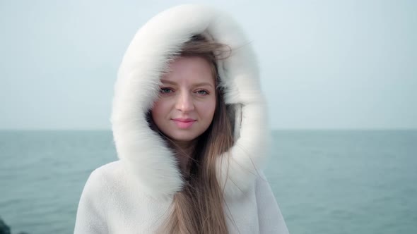 Young Woman Stands Against Lake Garda on City Embankment