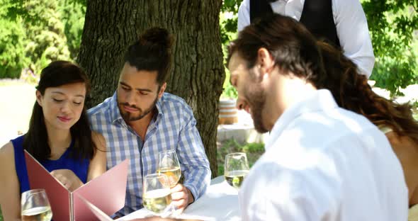 Waiter taking an order from couples