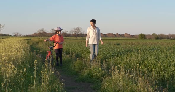 Child with mother ride a bike.