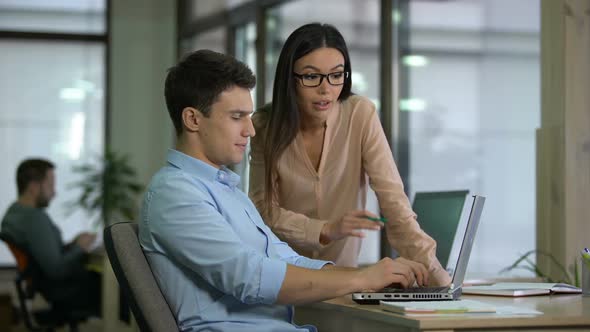 Female Chief Editor Controlling Work of Young Male Journalist, Approving Article