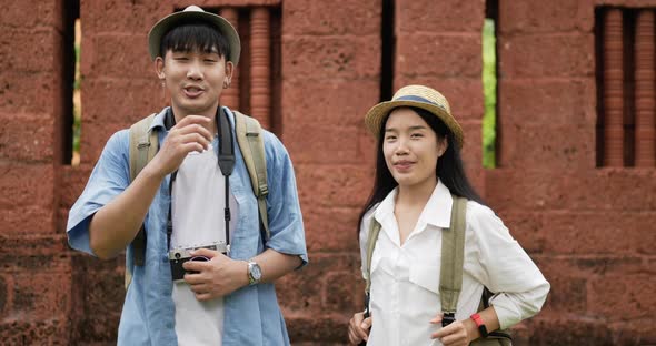 Couple videoblogger talking and looking at camera at ancient temple