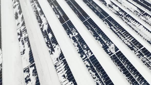 Aerial View of a Snow on Solar Panels Farm in Winter