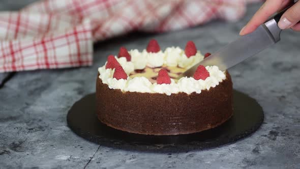 Cutting Homemade Raspberry Chocolate Cheesecake
