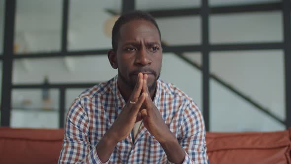 Pensive Black Man in Deep Thoughts Sitting on Sofa