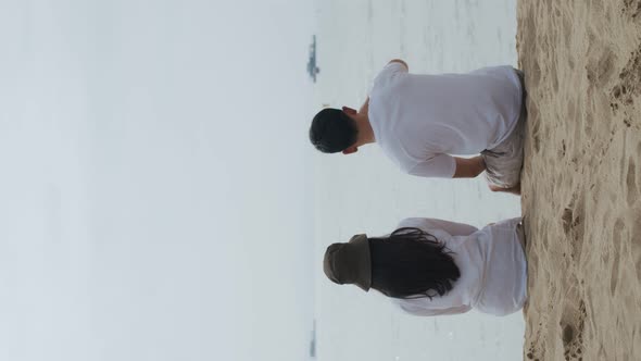 Asian couple in love happy cheerful sitting on the beach happiness on a holiday.