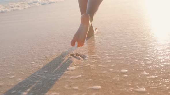 Close Up Slim Legs Woman Walking Barefoot on Wet Sand and Sea Waves