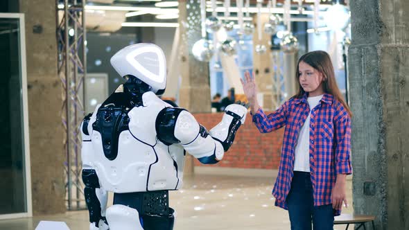 Futuristic Android Touching Hands with a Little Girl