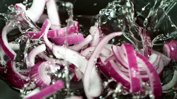 Super Slow Motion Shot of Falling Red Onion Cuts Into Oil in Pan at 1000 Fps.