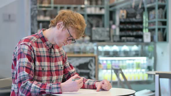 Young Redhead Man Trying To Write on Paper, Failure