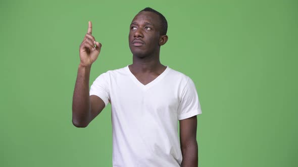 Young African Man Thinking While Pointing Up