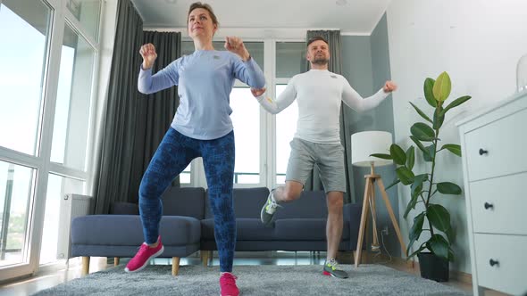 Caucasian Couple is Doing Cardio Exercise at Home in Cozy Bright Room