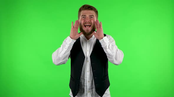 Man Screams Calling Someone on a Green Screen at Studio