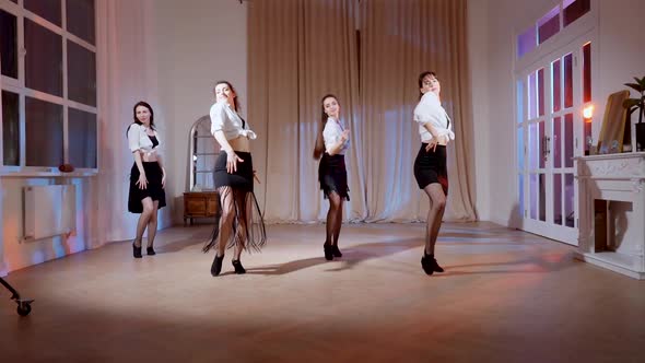 Four Girls in Black Skirts and White Shirts are Dancing Indoors