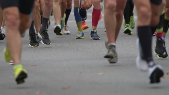 Slow Motion Shot of Marathon Running Race. People Feet on City Road