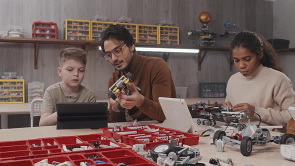 Teacher Helping Student To Build Construction