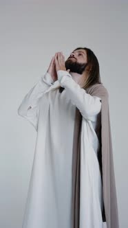 Jesus Prays with His Hands Together on a White Background