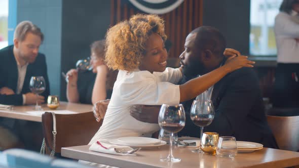 Portrait of Romantic Afro-american Couple Embracing on Date in Restaurant