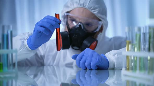 Scientist in Gas Mask Holding Test Tube With Dangerous Substance, Biohazard